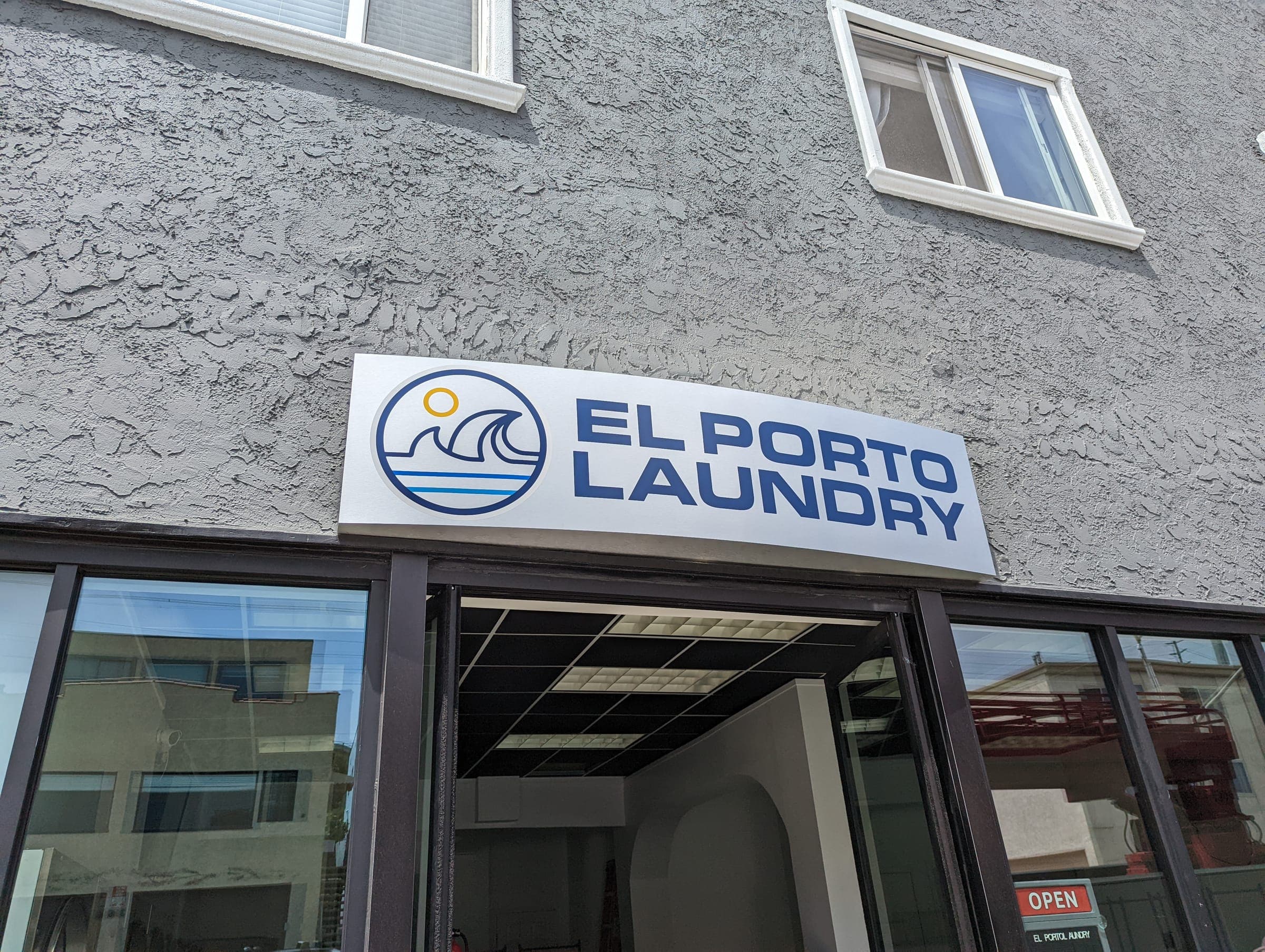 El Porto Laundry exterior sign close-up showing logo and name