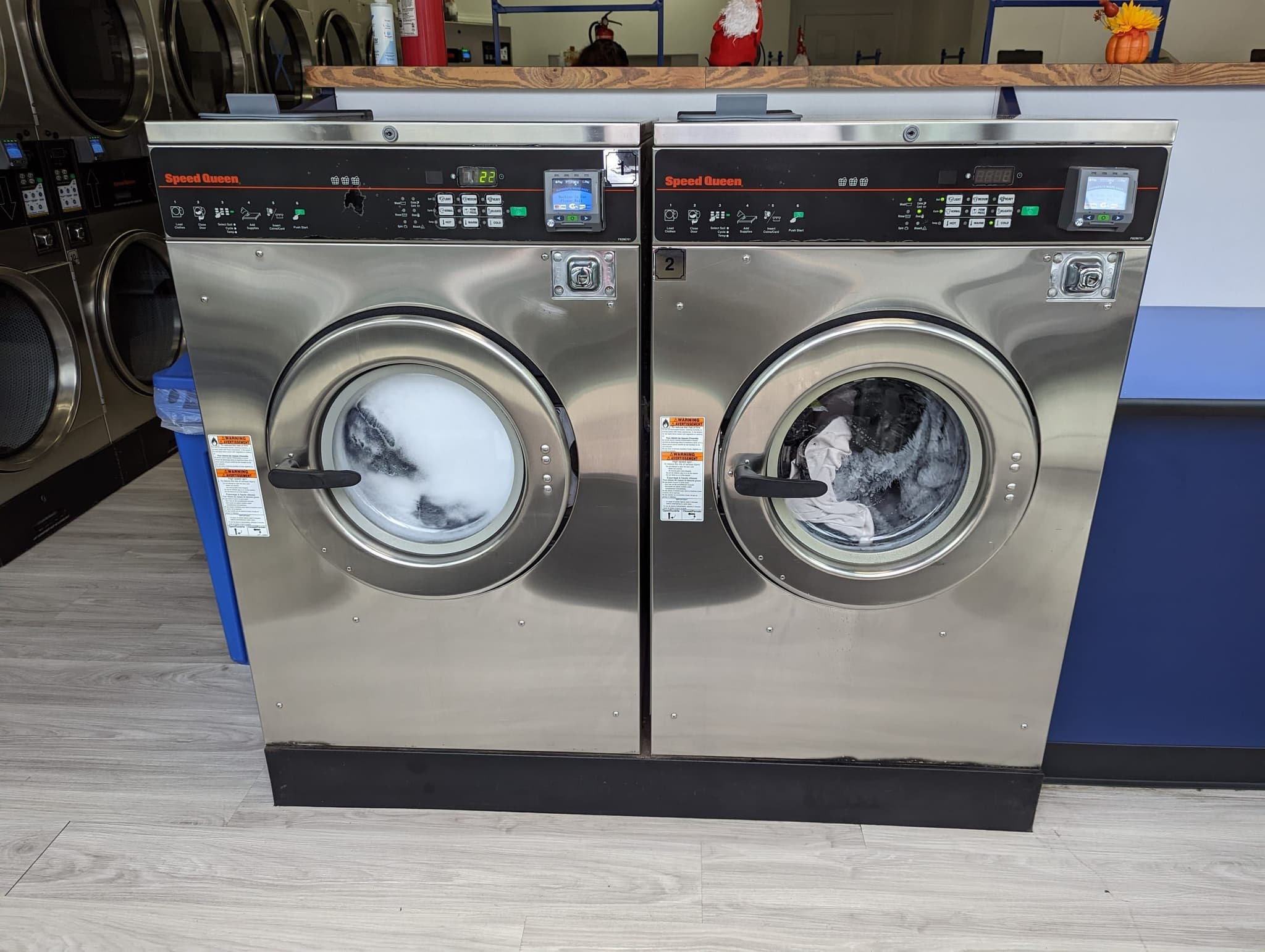 Speed Queen front-load washers running mid-cycle at El Porto Laundry's self-service laundromat