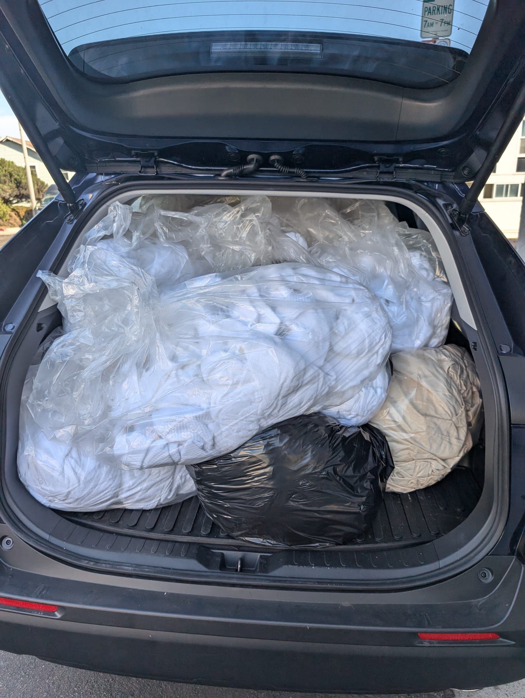 Wash-and-fold laundry pickup bags loaded into an El Porto Laundry delivery vehicle