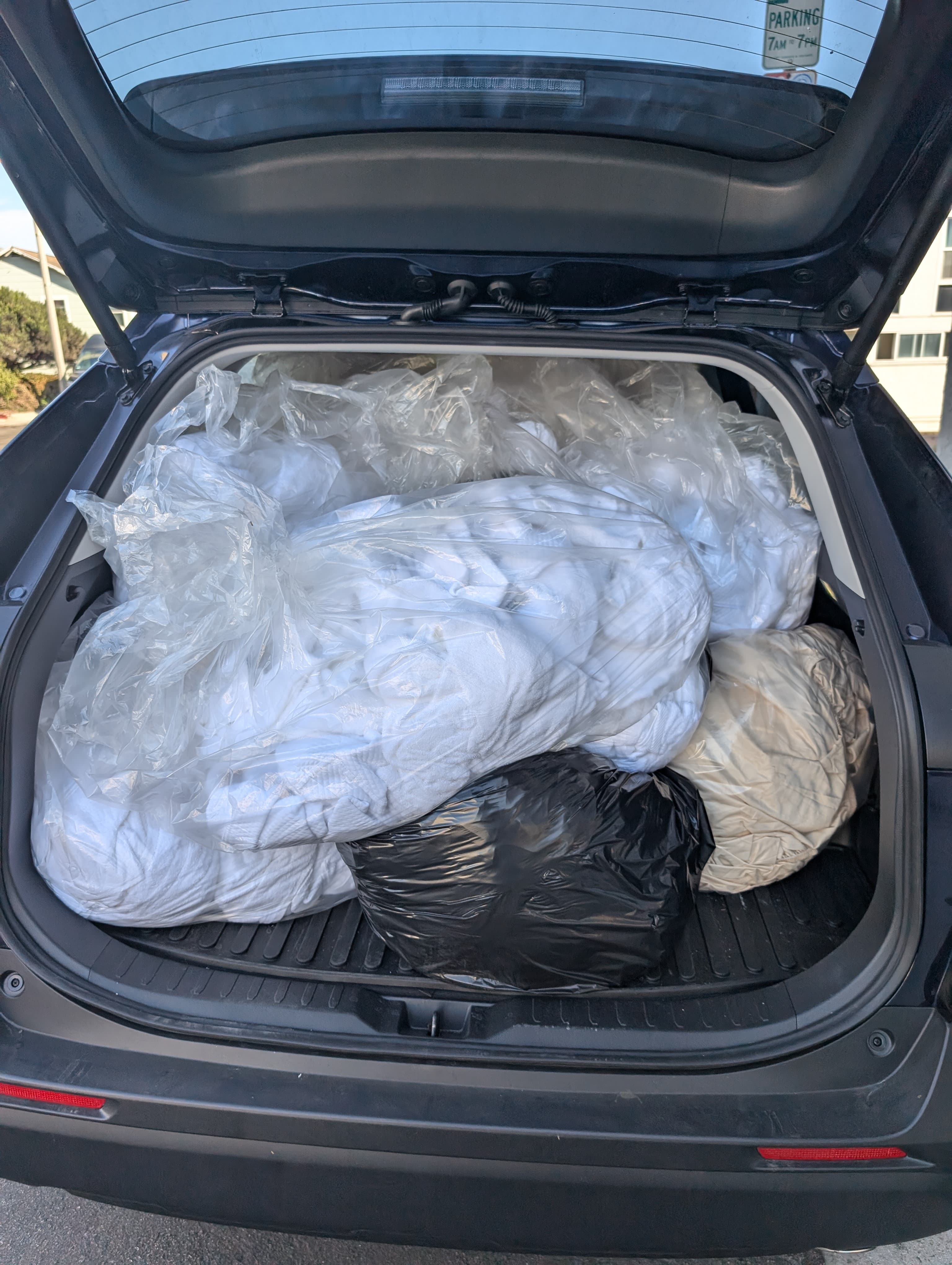 Wash-and-fold laundry pickup bags loaded into an El Porto Laundry delivery vehicle